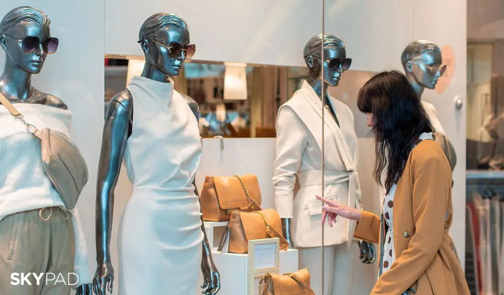 Perfecting the CX: Delivering Luxury Seamlessly 1 a woman looking at a mannequin in a store